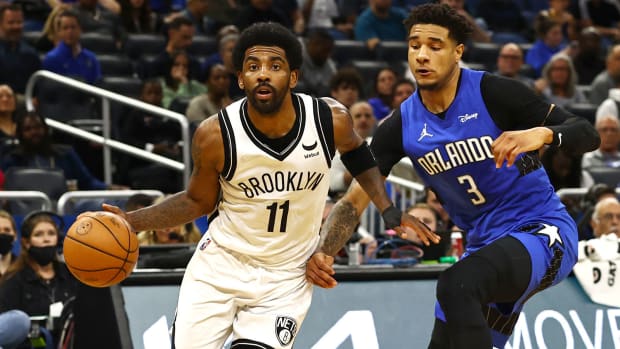 Brooklyn Nets guard Kyrie Irving drives to the basket as Orlando Magic forward Chuma Okeke defends.